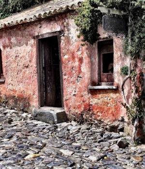 cool photography, old motel located in Uruguay red walls old wooden door and cobble stone street